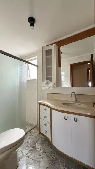 Foto de um banheiro com revestimento de cerâmica e armário branco.