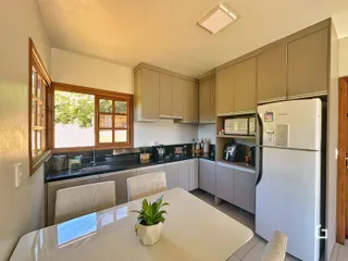 Vista da cozinha e sala de jantar com armários e janela em Lajeado.