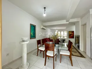 Ambiente interno de sala de jantar com piso de cerâmica e móveis de madeira.