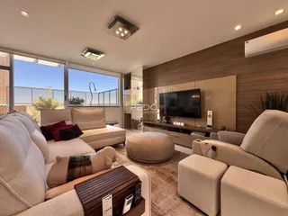 Sala de estar moderna com sofá e decoração em tons neutros.