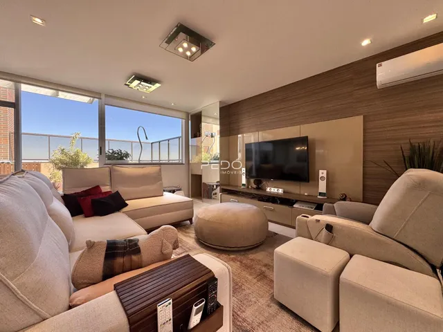 Sala de estar moderna com sofá e decoração em tons neutros.