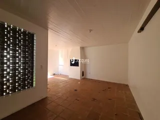 Interior de uma sala com piso de cerâmica e janela grande.