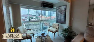 Sala de estar com vista para a rua através de uma grande janela.