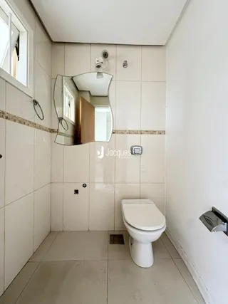 Foto de um banheiro interno com azulejos brancos e vaso sanitário.
