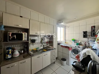Foto de uma cozinha moderna com armários brancos e piso cerâmico.