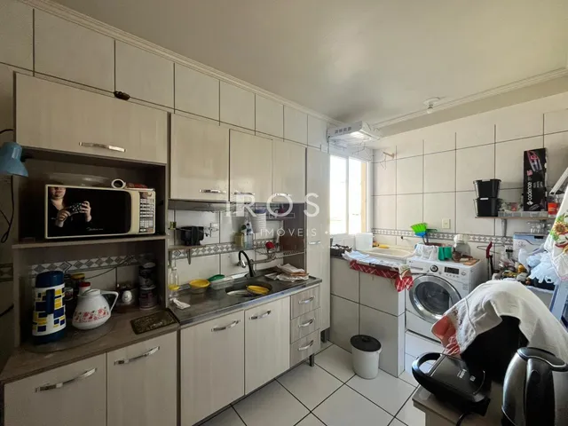 Foto de uma cozinha moderna com armários brancos e piso cerâmico.