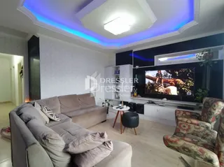 Sala de estar com sofá e televisão em um apartamento.