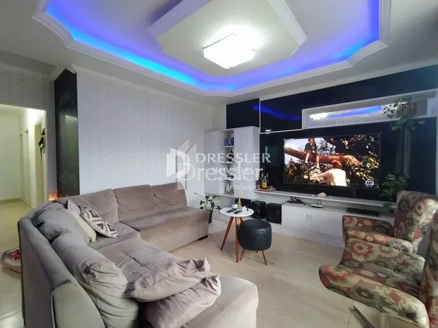 Sala de estar com sofá e televisão em um apartamento.