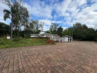 Vista externa de uma propriedade em Lajeado, Brasil, com uma grande área pavimentada na frente.