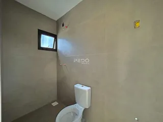 Foto de um banheiro interno com paredes neutras e um vaso sanitário branco.