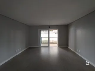 Hall de entrada com piso de madeira clara e paredes brancas.