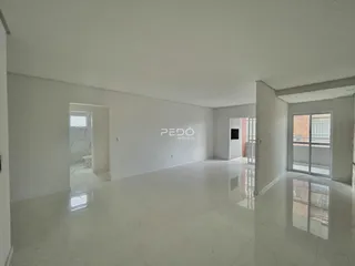 Vista de um corredor amplo e iluminado em um imóvel.