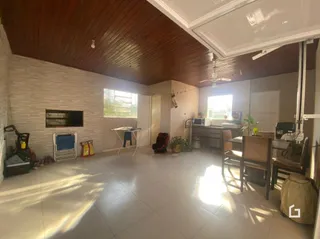 Sala com teto de madeira e piso de cerâmica.