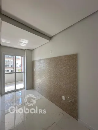 Interior de uma sala com piso de mármore e parede texturizada.