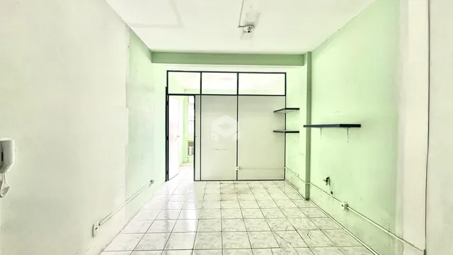 Corredor interno com piso de cerâmica claro.