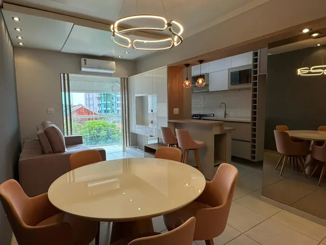 Sala de jantar com mesa redonda e cadeiras em ambiente interno.