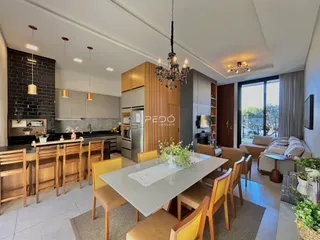 Sala de estar e cozinha moderna com mesa de jantar e ilha.
