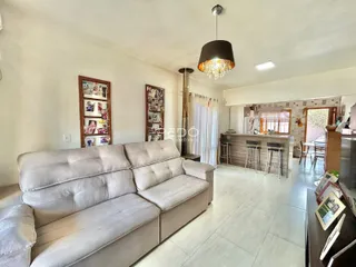 Sala de estar com um sofá grande e piso de cerâmica claro.