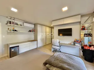 Sala de estar moderna com armários embutidos e televisão na parede.