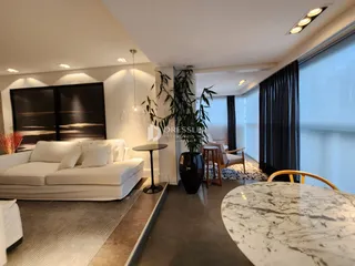 Sala de estar moderna com sofá branco e piso de madeira clara.