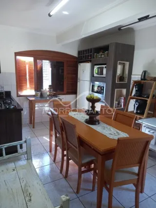 Foto de um ambiente interno com mesa de jantar de madeira e armários.