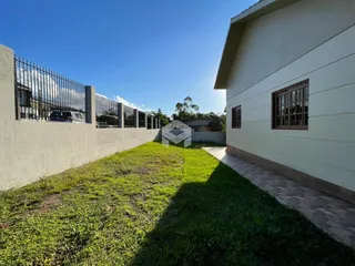 Fachada de uma residência com muro e gramado verde.