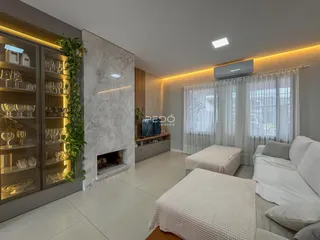 Sala de estar moderna com estantes e lareira em um apartamento no Brasil.