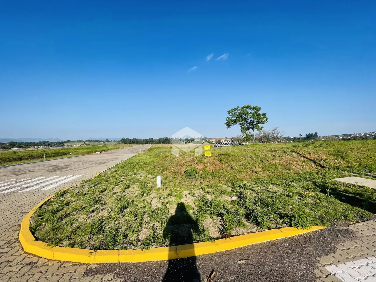 Paisagem de campo com grama seca e uma estrada no primeiro plano.