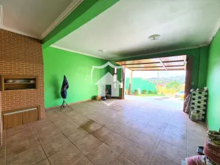 Interior de uma sala com parede de tijolos e teto verde vibrante.