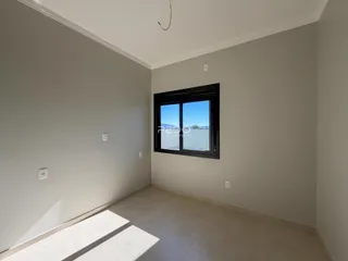 Interior de um ambiente com paredes brancas e piso claro.