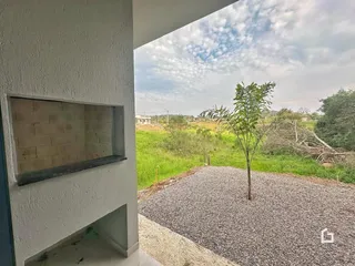 Vista externa de uma parede e paisagem com vegetação ao fundo.