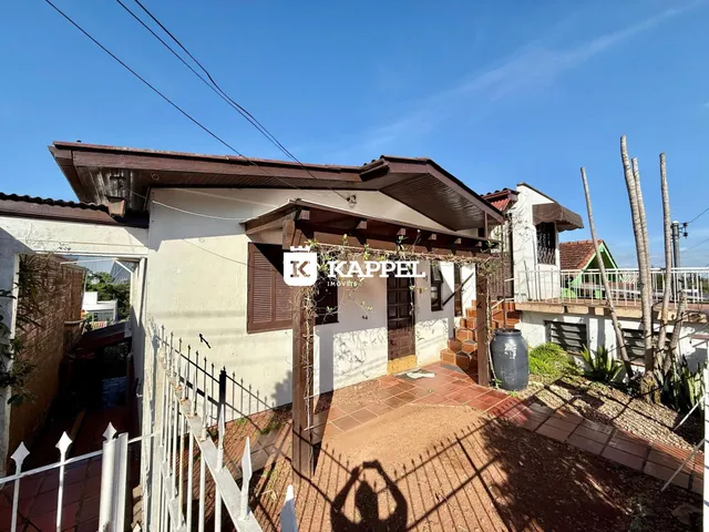 Fachada de uma casa residencial em Lajeado, Brasil, com cerca e jardim na frente.