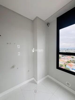 Vista interna de um ambiente com paredes brancas e piso de cerâmica.