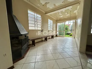 Ambiente interno com piso de cerâmica e teto com danos visíveis.