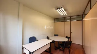Ambiente interno com mesa e cadeiras em piso de madeira.