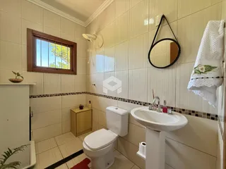 Banheiro com revestimento cerâmico nas paredes e piso.
