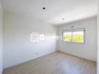 Foto de um cômodo interno com paredes brancas e piso de madeira clara.