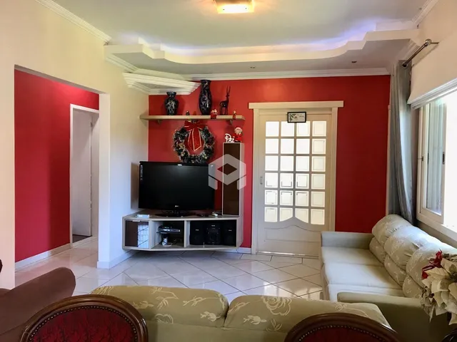 Sala de estar com paredes vermelhas e móveis de madeira.