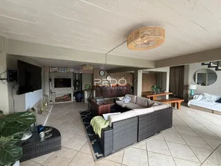 Sala de estar com piso de cerâmica e sofá de vime.