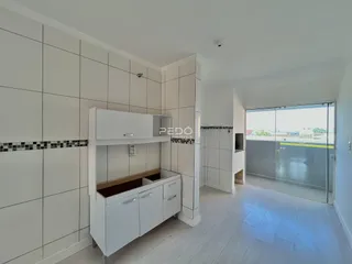 Interior de uma sala com revestimento de parede branco e piso de madeira clara.