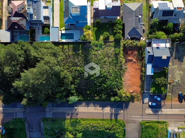 Vista aérea de propriedades residenciais em Lajeado, Brasil, com vegetação densa.
