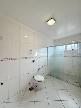 Foto de um banheiro interno com piso de cerâmica branco.