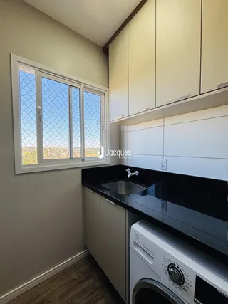 Cozinha moderna com armários brancos e bancada escura.