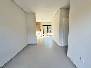 Corredor interno moderno com paredes brancas e piso claro.