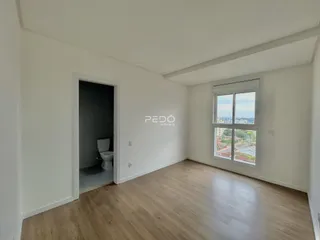 Ambiente interno de uma sala com piso de madeira e janela em um imóvel em Lajeado.