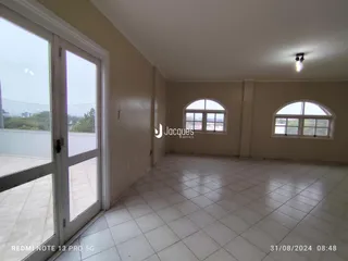 Sala de estar com piso de cerâmica e janelas arqueadas.