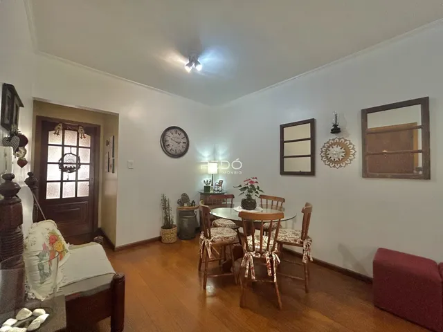 Sala de jantar com piso de madeira e móveis de madeira no interior de uma residência.