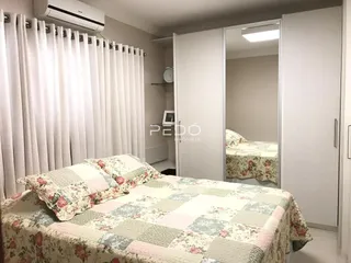 Quarto com cama e cortinas brancas em um imóvel no Brasil.