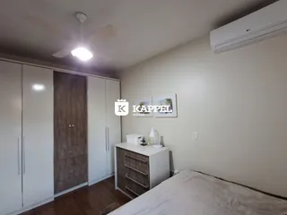 Este é um quarto com armários brancos e piso de madeira.