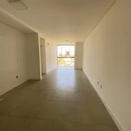 Foto de um corredor interno com paredes brancas e piso claro.